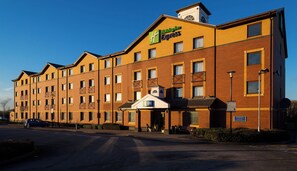 A Holiday Inn Express hotel with a brick facade, multiple windows, and a clear sky. - Holiday Inn Express Stoke On Trent by IHG (Stoke-on-Trent)