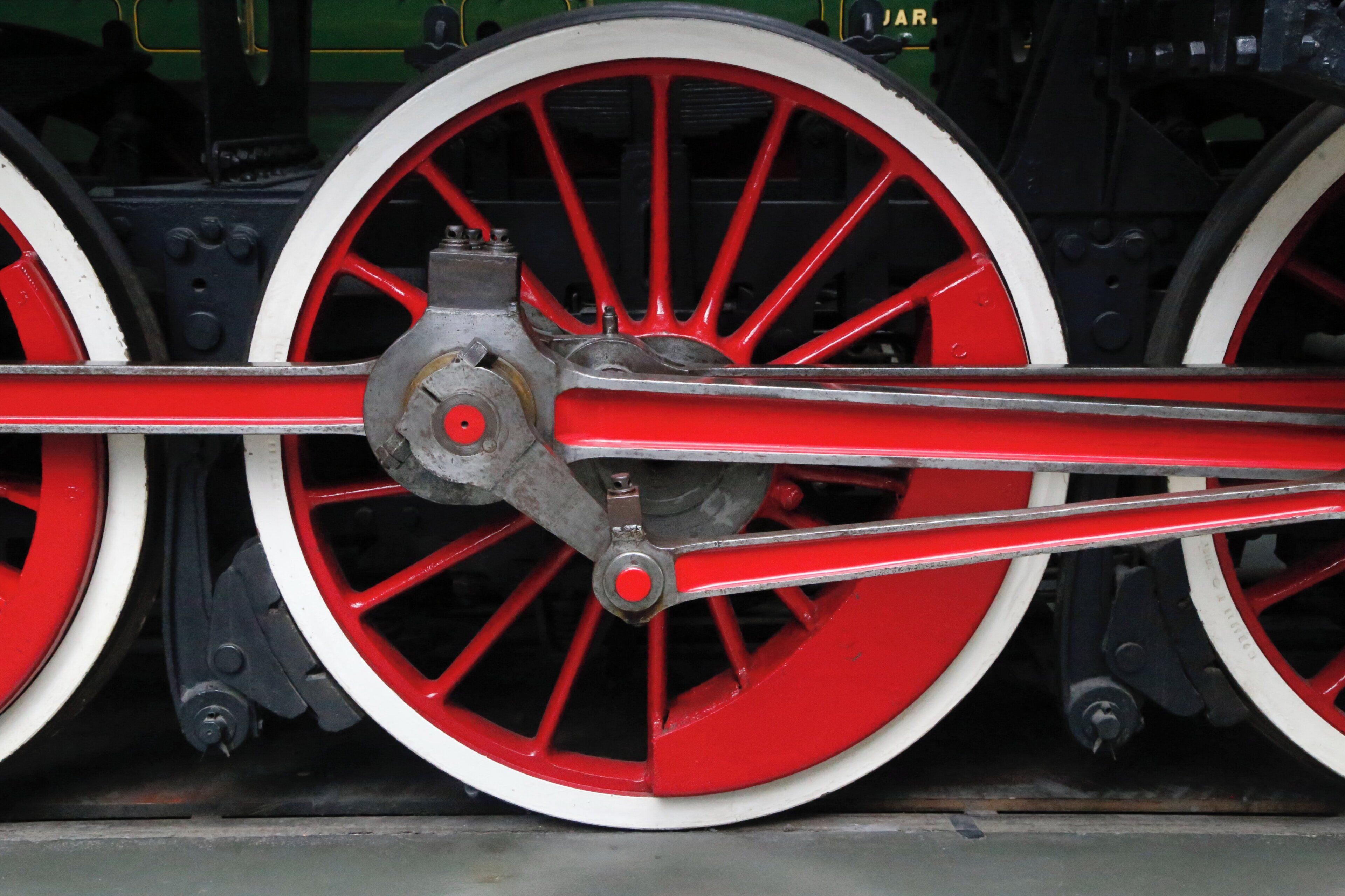 A close-up of a train wheel with red spokes and a central hub.