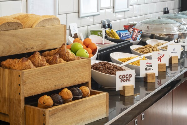 A breakfast buffet with various food items including croissants, muffins, fruits, and cereals. - Holiday Inn Express York by IHG (York)