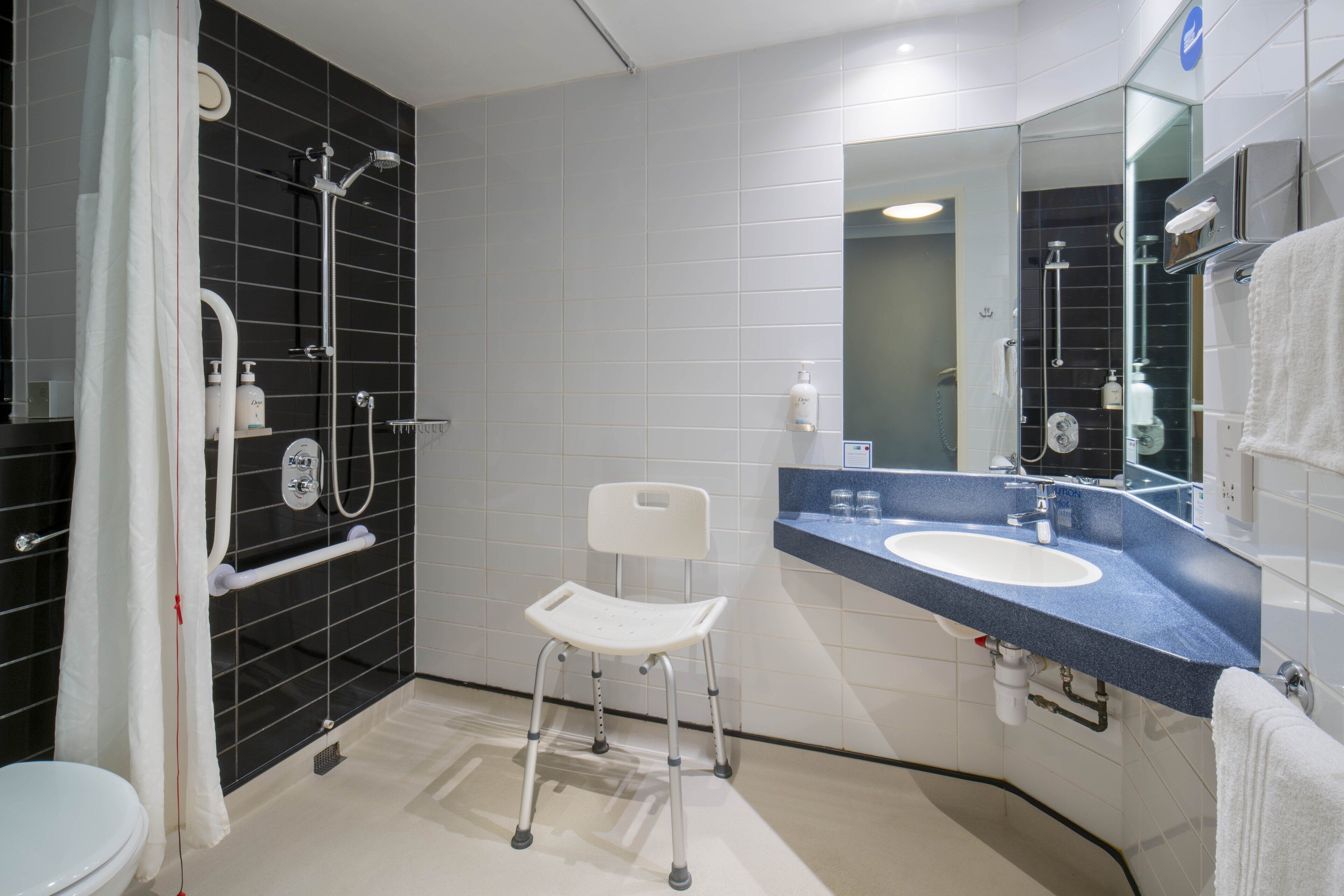 A modern bathroom with a shower, toilet, and sink.