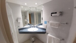 A modern bathroom with a dual sink, a large mirror, and a towel rack.