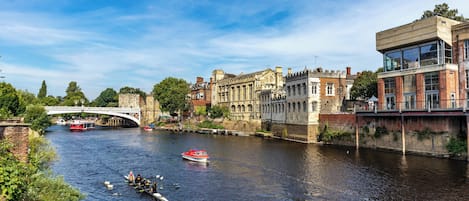A river with boats, a bridge, and historic buildings.