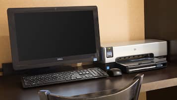 A Dell Inspiron desktop computer with a keyboard and mouse on a wooden desk.