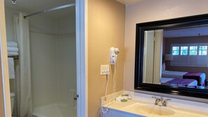 Un bagno con vasca, lavabo, specchio e tenda della doccia.
