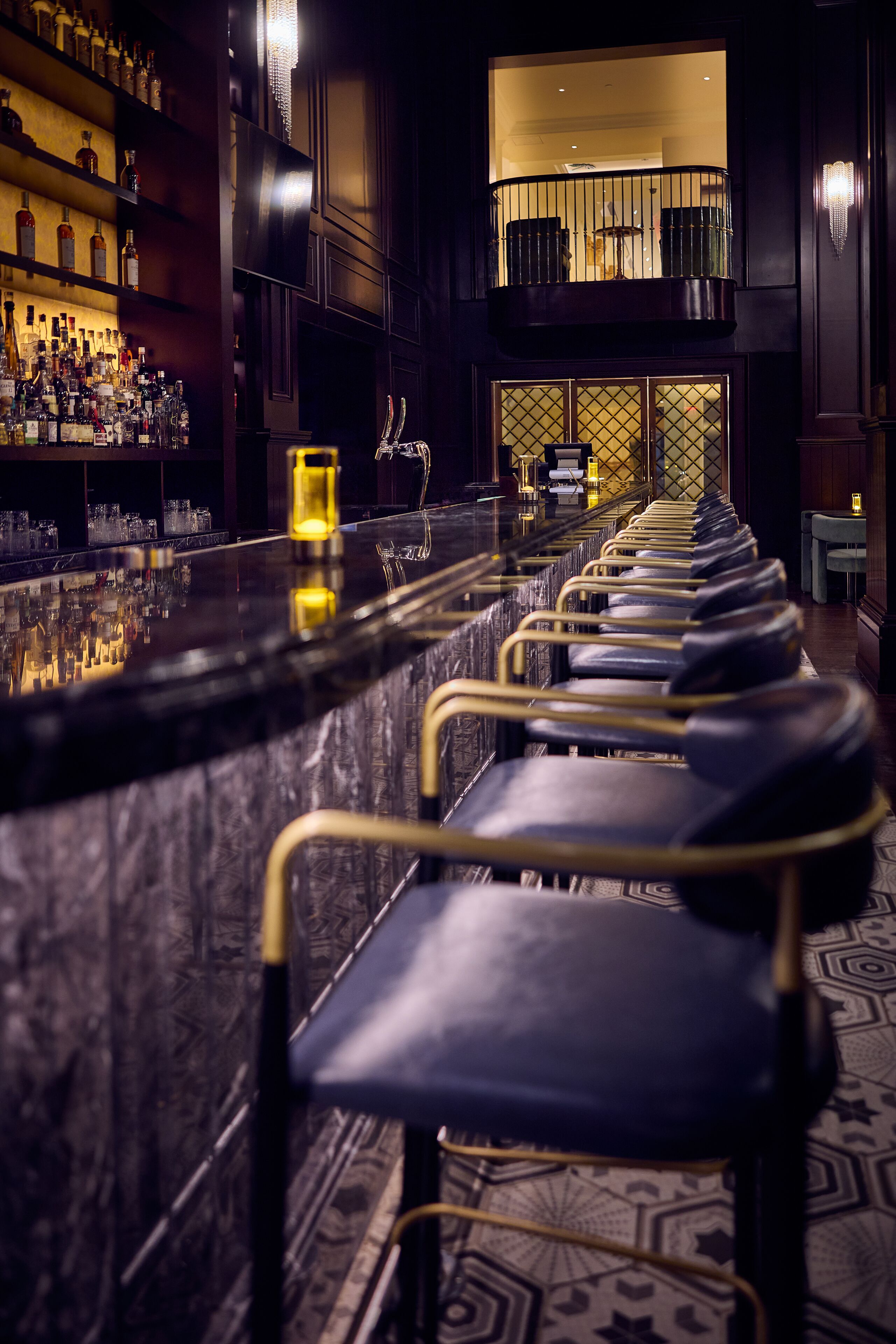 Un espace bar avec un long comptoir et des rangées de chaises.