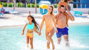 En familie på fire ved et strandresort, der går i lavt vand.