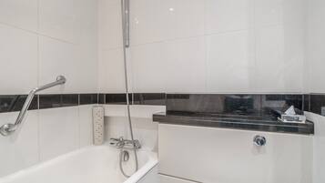 A bathroom with a bathtub, a shower, and a toilet.