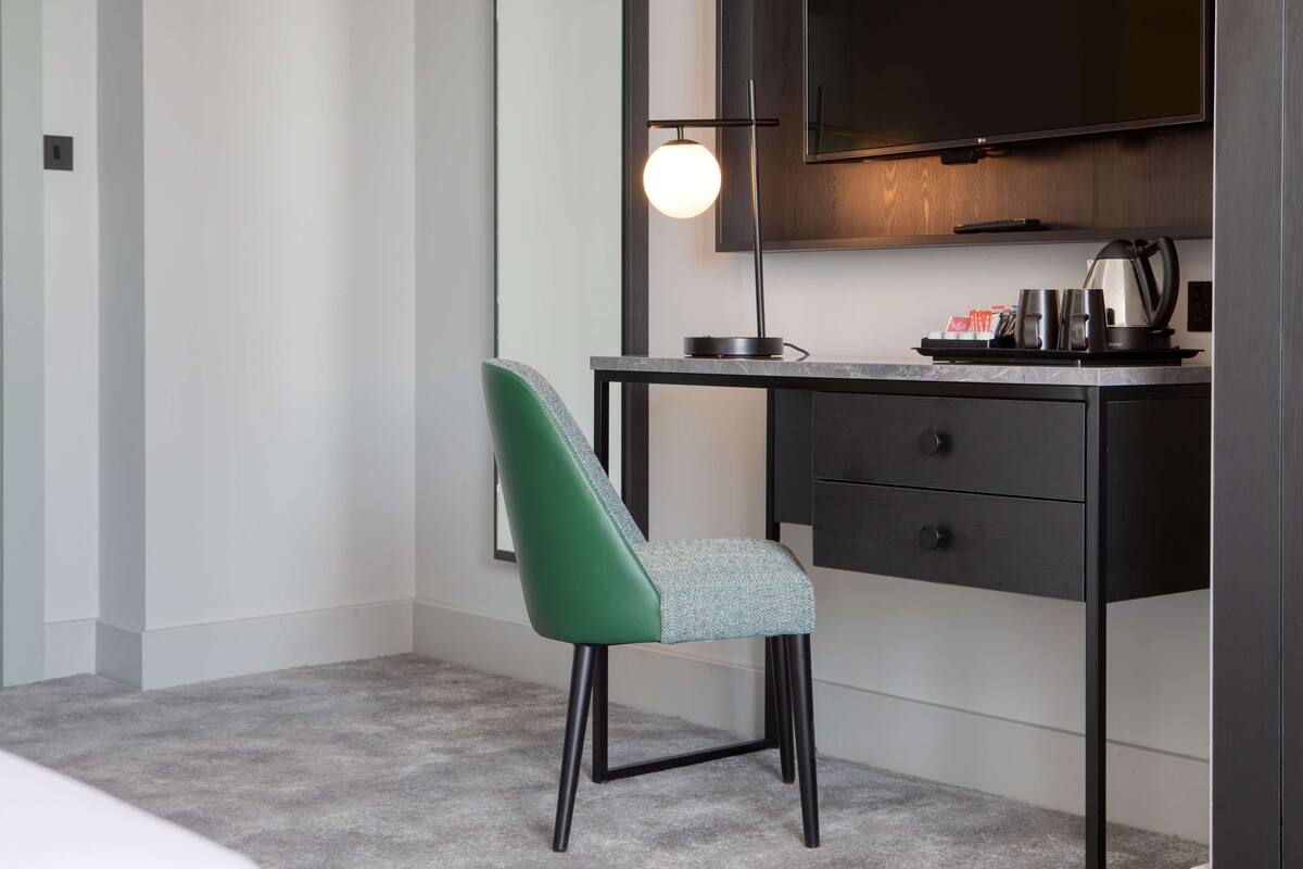 A modern office space with a desk, chair, and a mounted television.