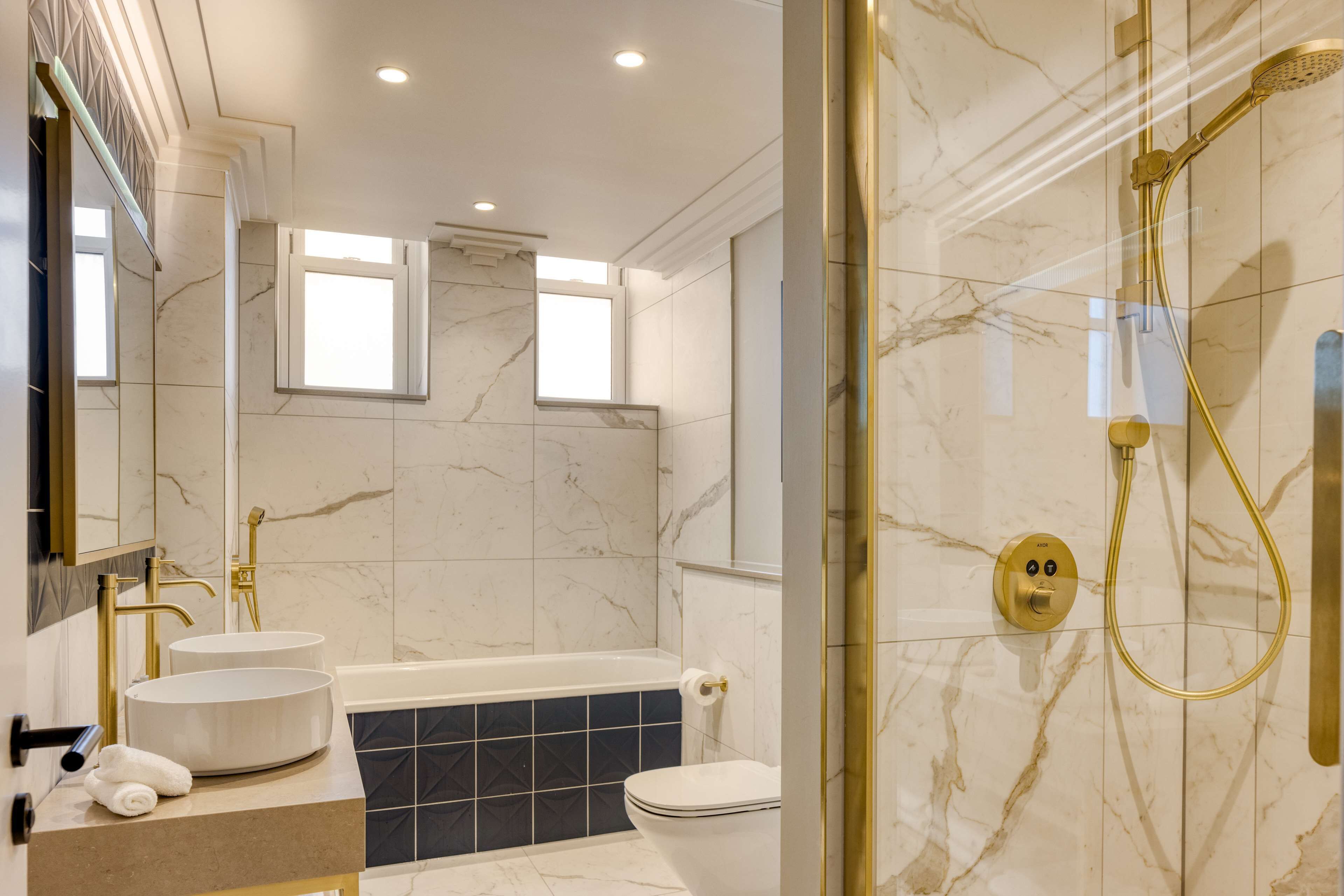 A modern bathroom with a bathtub, a toilet, and a shower area.