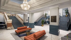 A grand lobby with marble floors, a chandelier, a staircase, and seating areas. - DoubleTree by Hilton Brighton Metropole (Brighton)