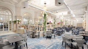 A spacious hotel lobby with multiple seating areas, a reception desk, and a bar. - DoubleTree by Hilton Brighton Metropole (Brighton)