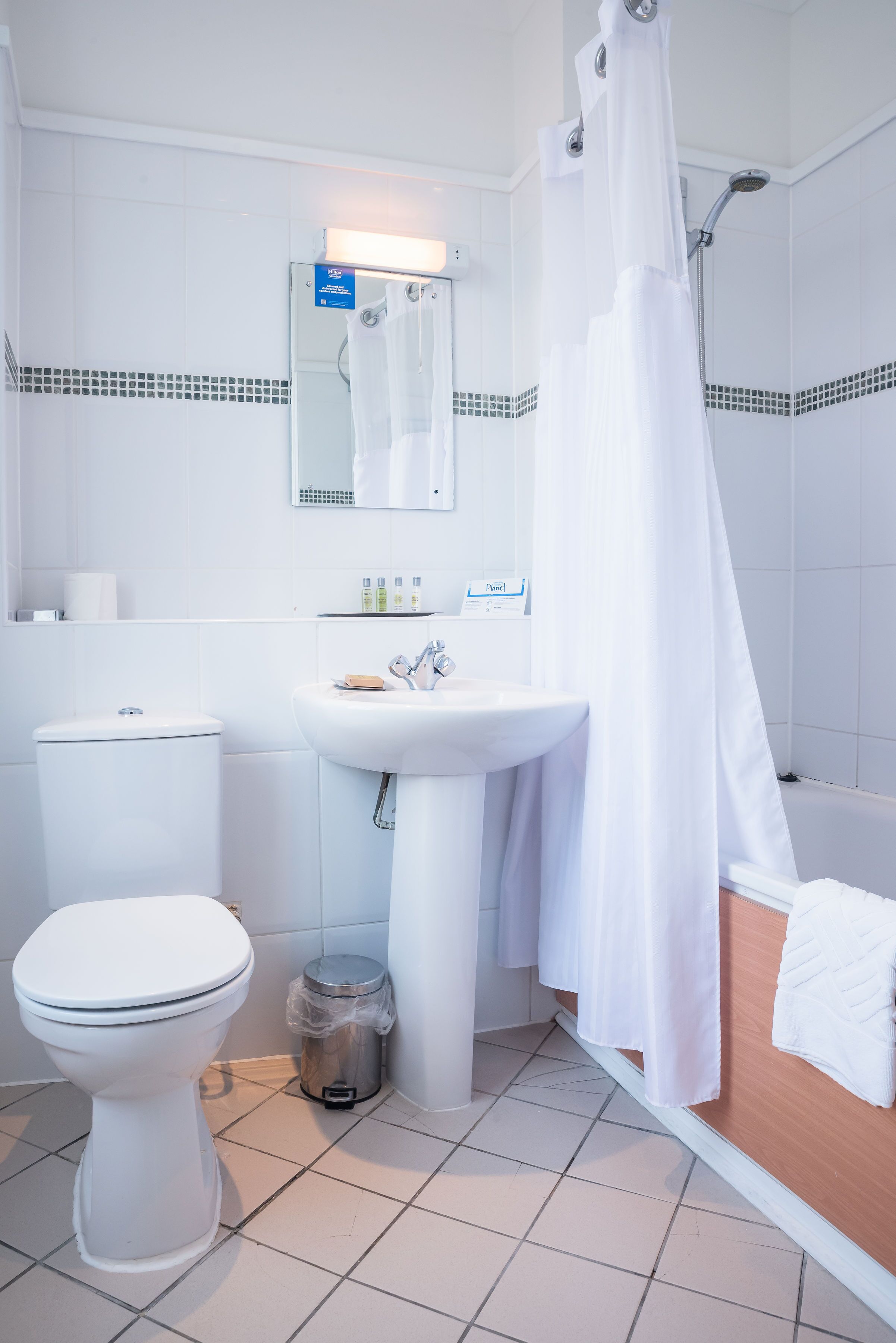 A bathroom with a toilet, sink, and shower area.