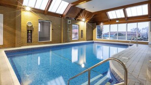 An indoor swimming pool with skylights, a clock, and a no smoking sign on the wall. - Avisford Park Hotel (Arundel)