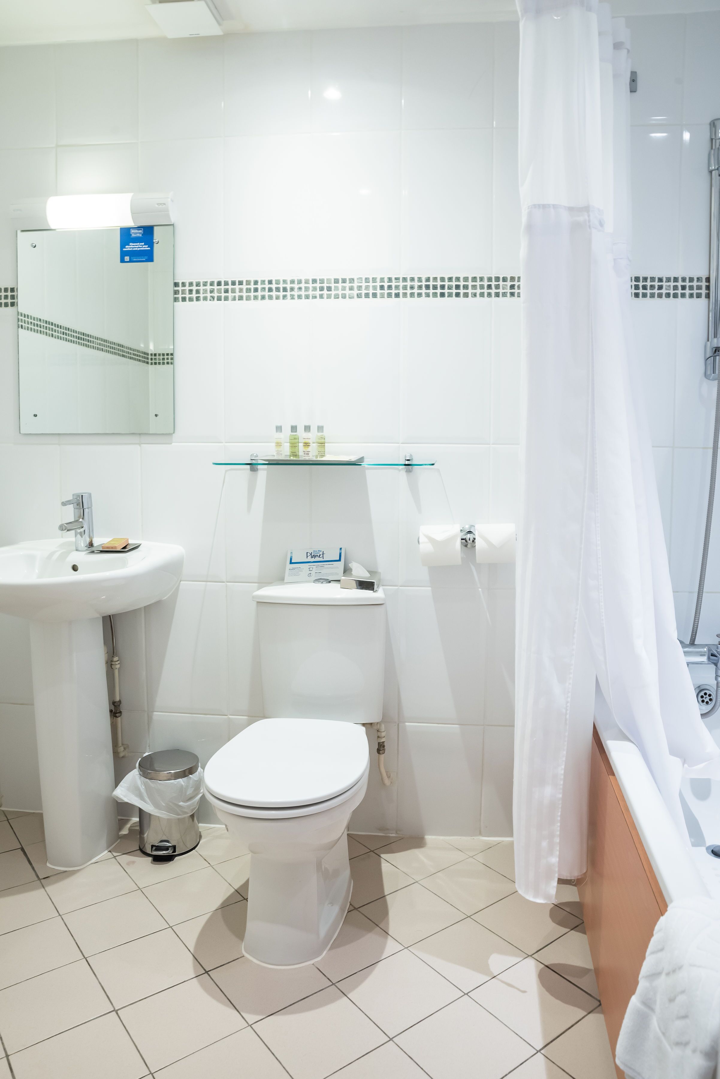 A modern bathroom with a toilet, sink, and shower.
