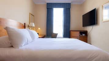 Habitación de hotel con una cama grande, un televisor de pantalla plana, un escritorio y una silla.