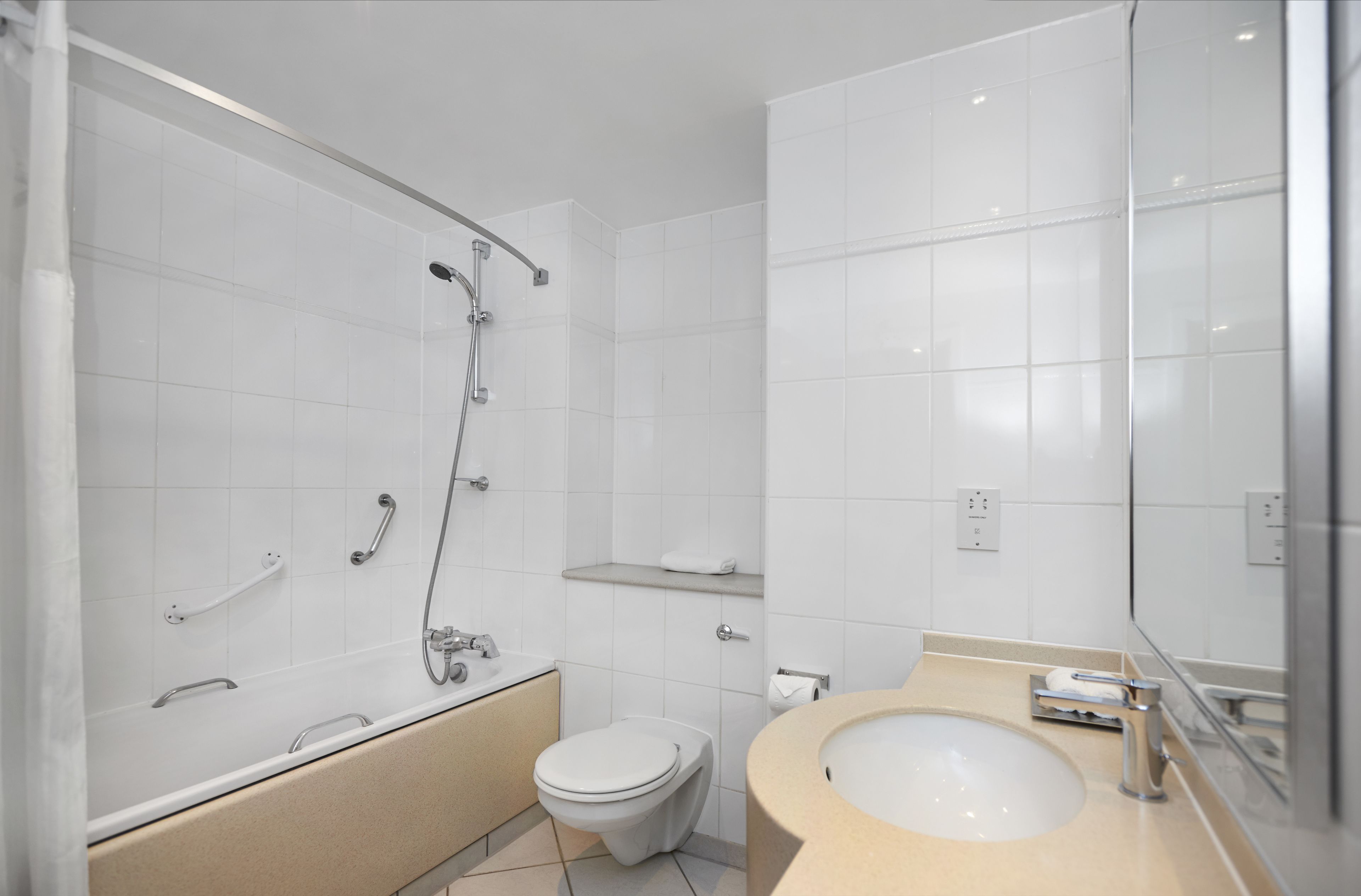 Un bagno moderno con vasca, water e lavandino.