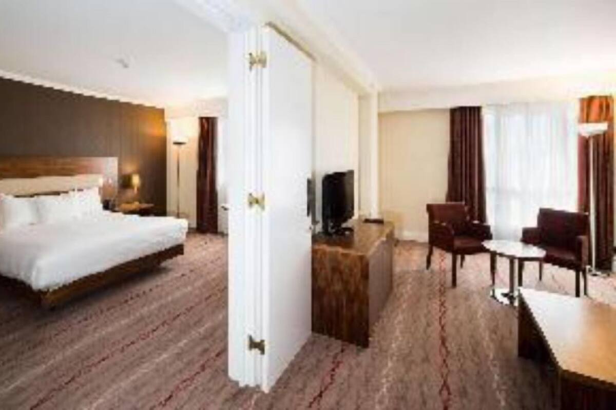 Een hotelkamer met een groot bed, een bureau, een stoel en een televisie.