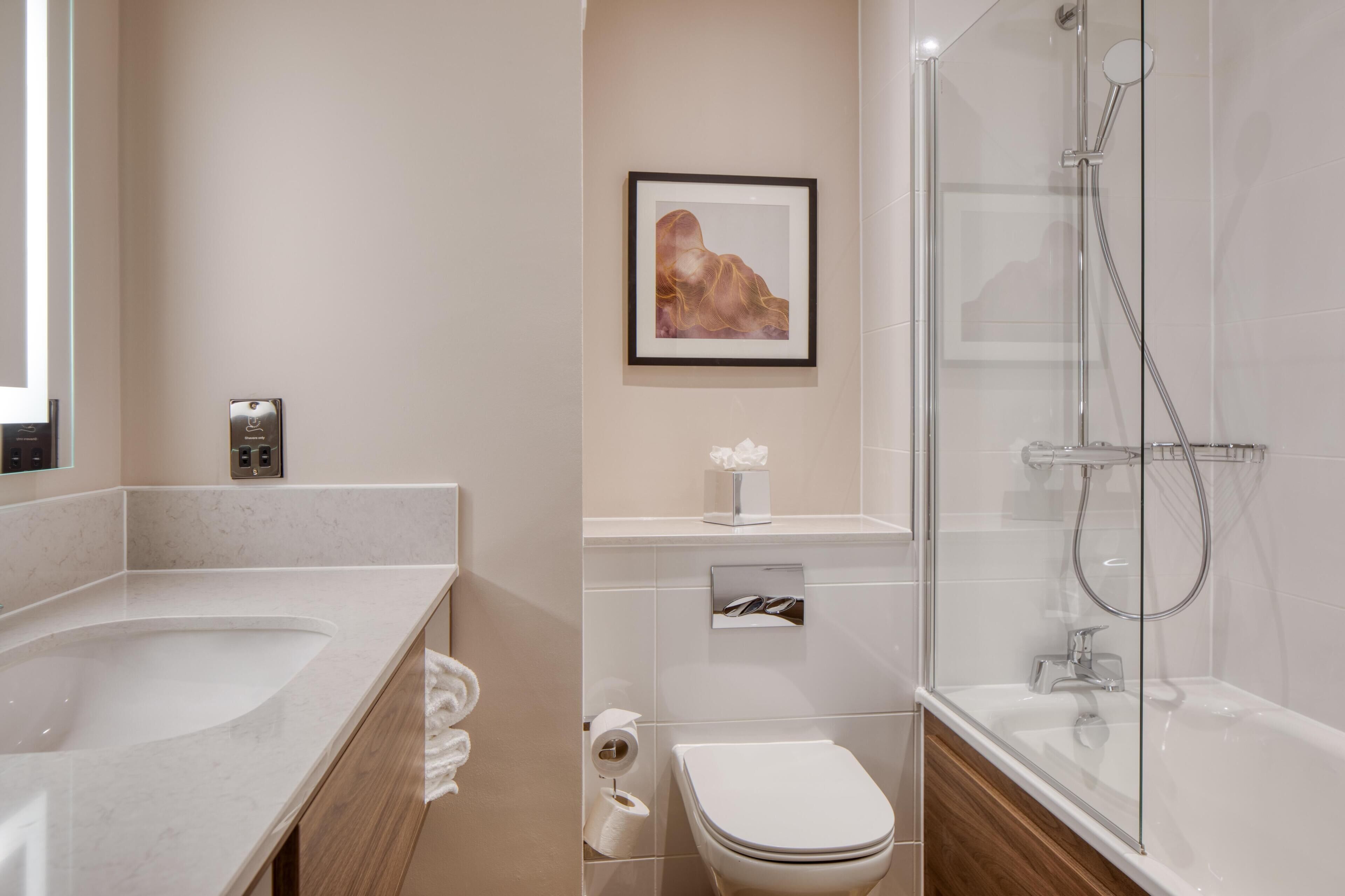 A modern bathroom with a bathtub, toilet, and sink.