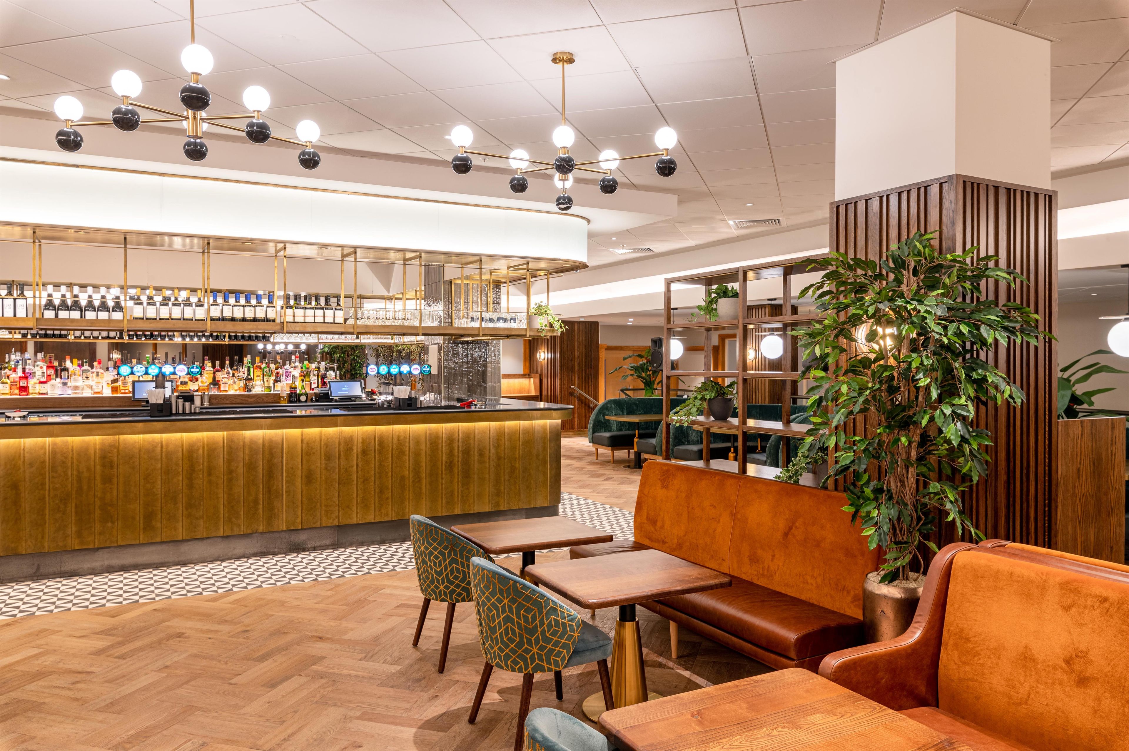 A bar area with a counter, seating, and a large potted plant.