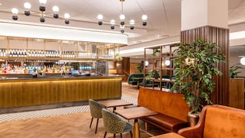 A bar area with a counter, seating, and a large potted plant.