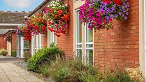 A brick building with hanging flower baskets. - Bromsgrove Hotel (Bromsgrove)