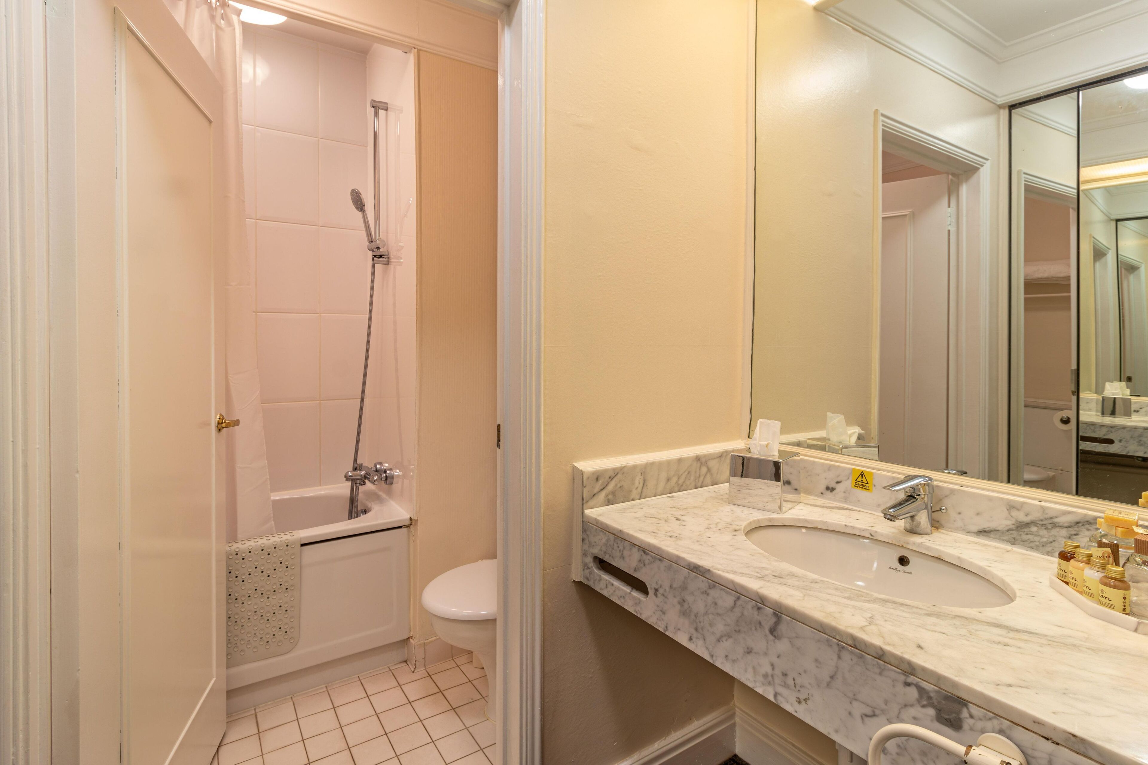 Bagno con doccia, WC e doppio lavabo con piano in marmo.