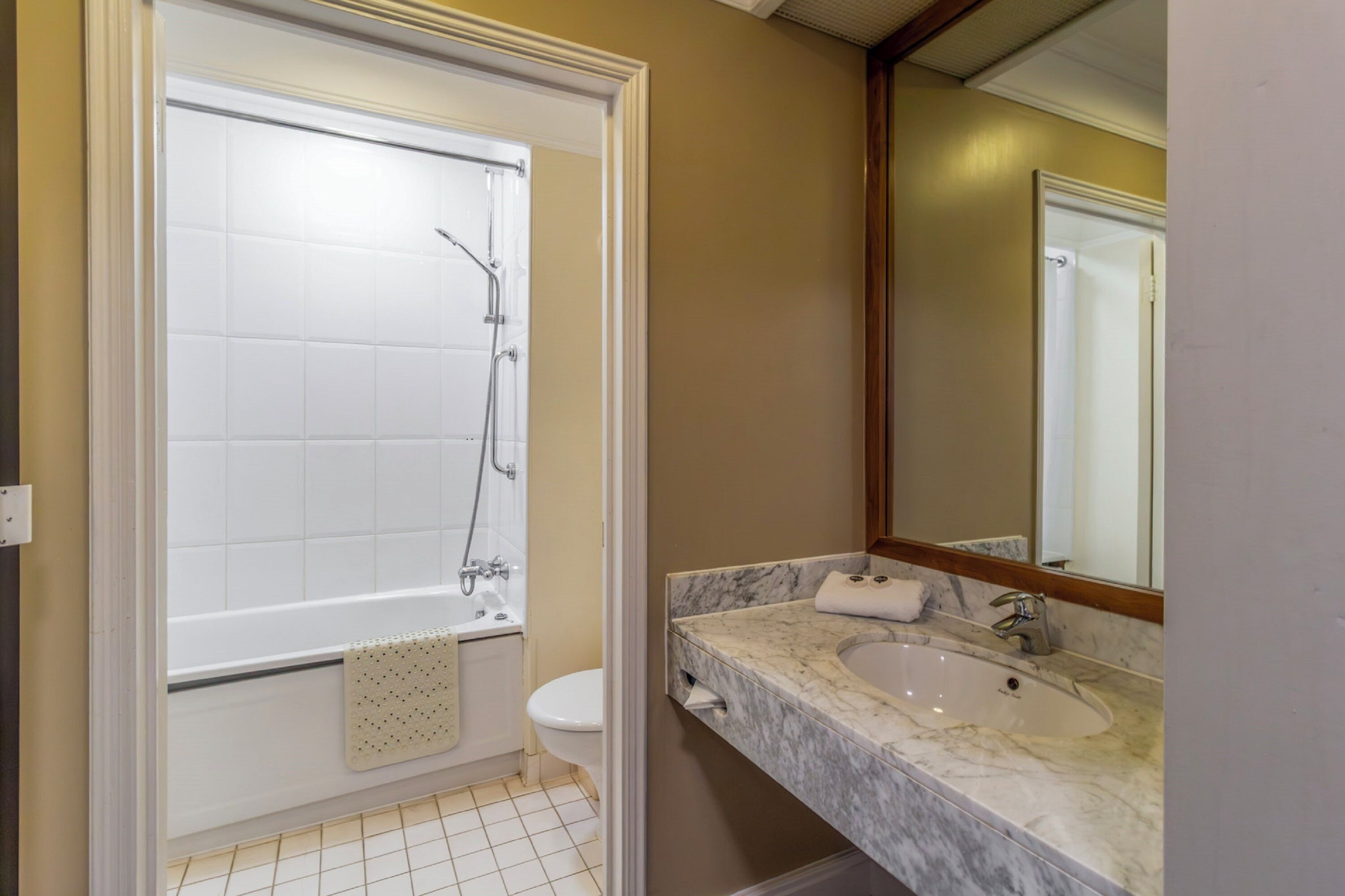 A bathroom with a bathtub, toilet, and sink.