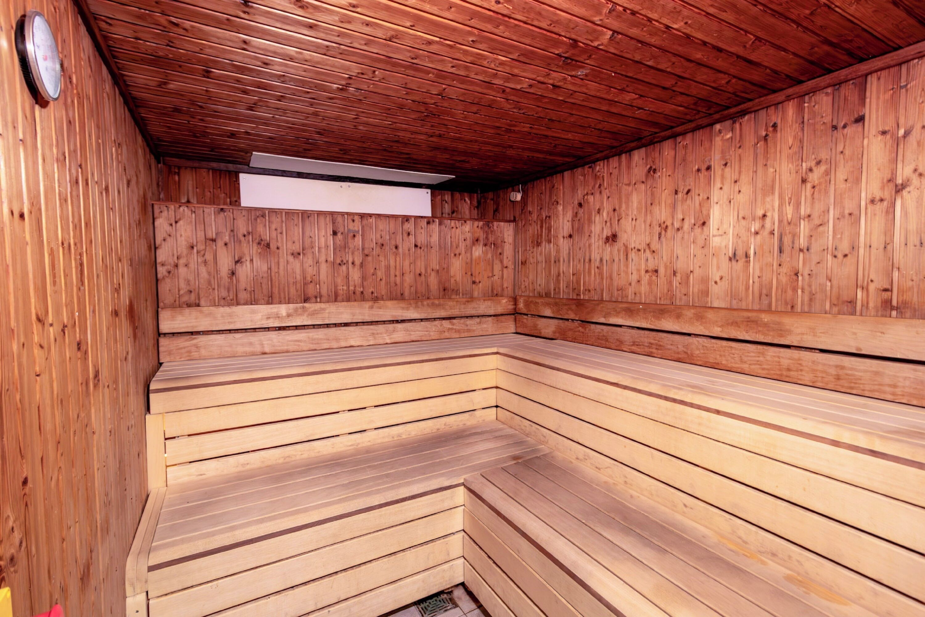 A sauna with wooden benches arranged in a semi-circular pattern.