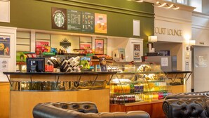 A coffee shop with a counter, seating area, and a sign for the court lounge. - Bromsgrove Hotel (Bromsgrove)