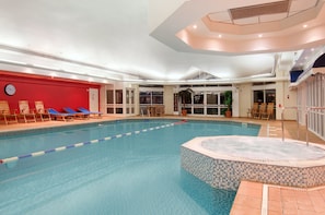 Een binnenzwembad en ligstoelen