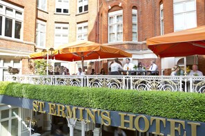 Hotel St. Ermin's met terras en een haag ervoor.