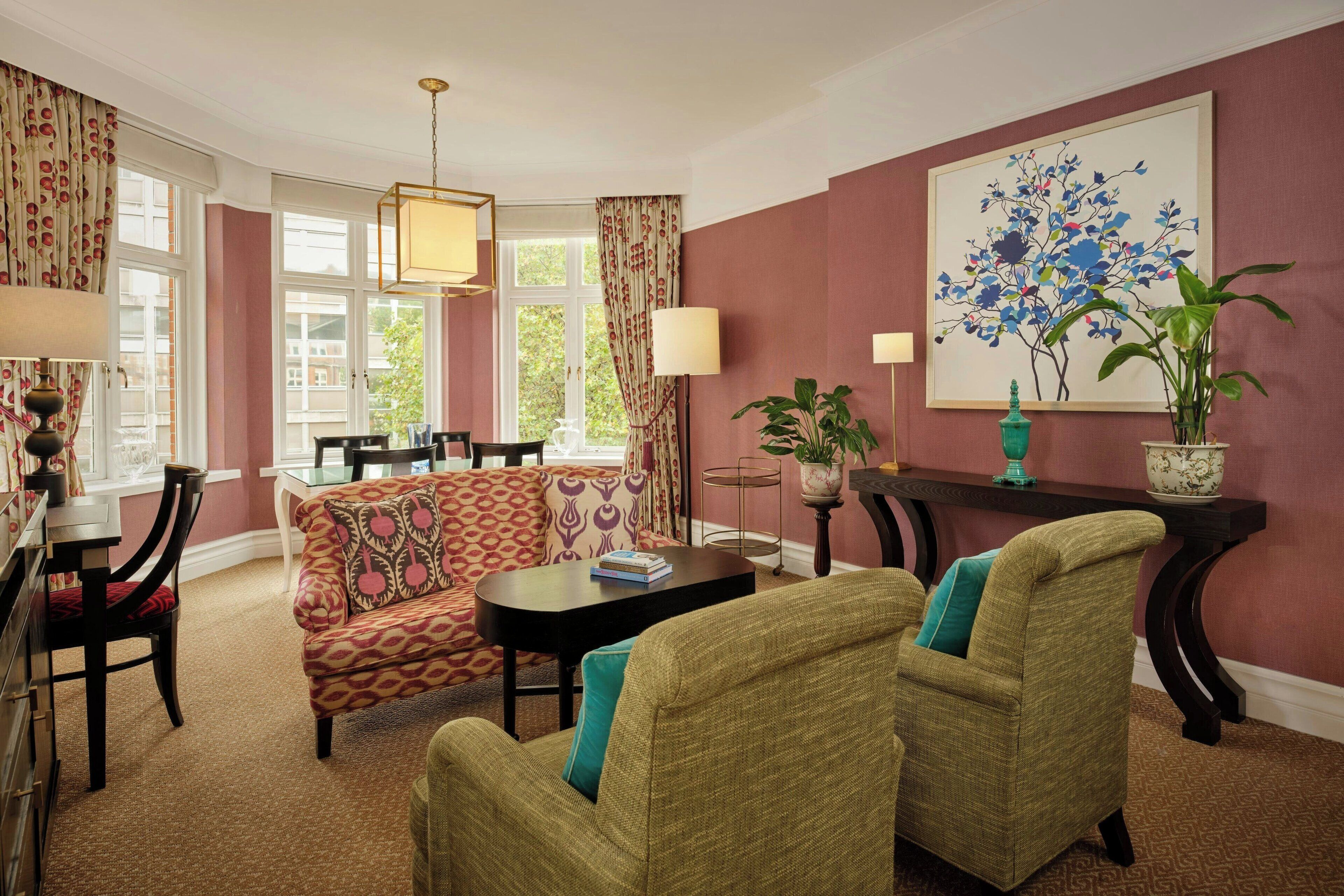 A cozy living room with a sofa, chairs, a coffee table, and a dining area with chairs and a table.