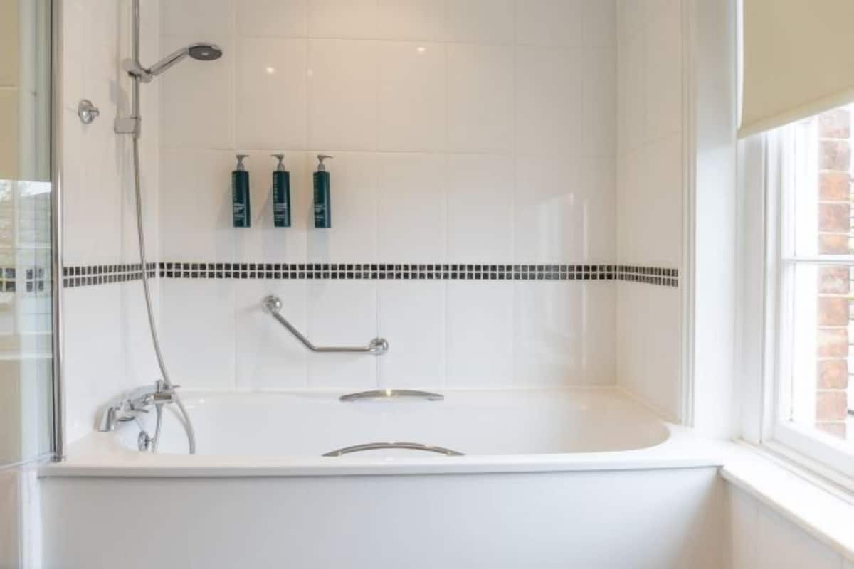 Badkamer | Een bad/douchecombinatie, gratis toiletartikelen, een haardroger