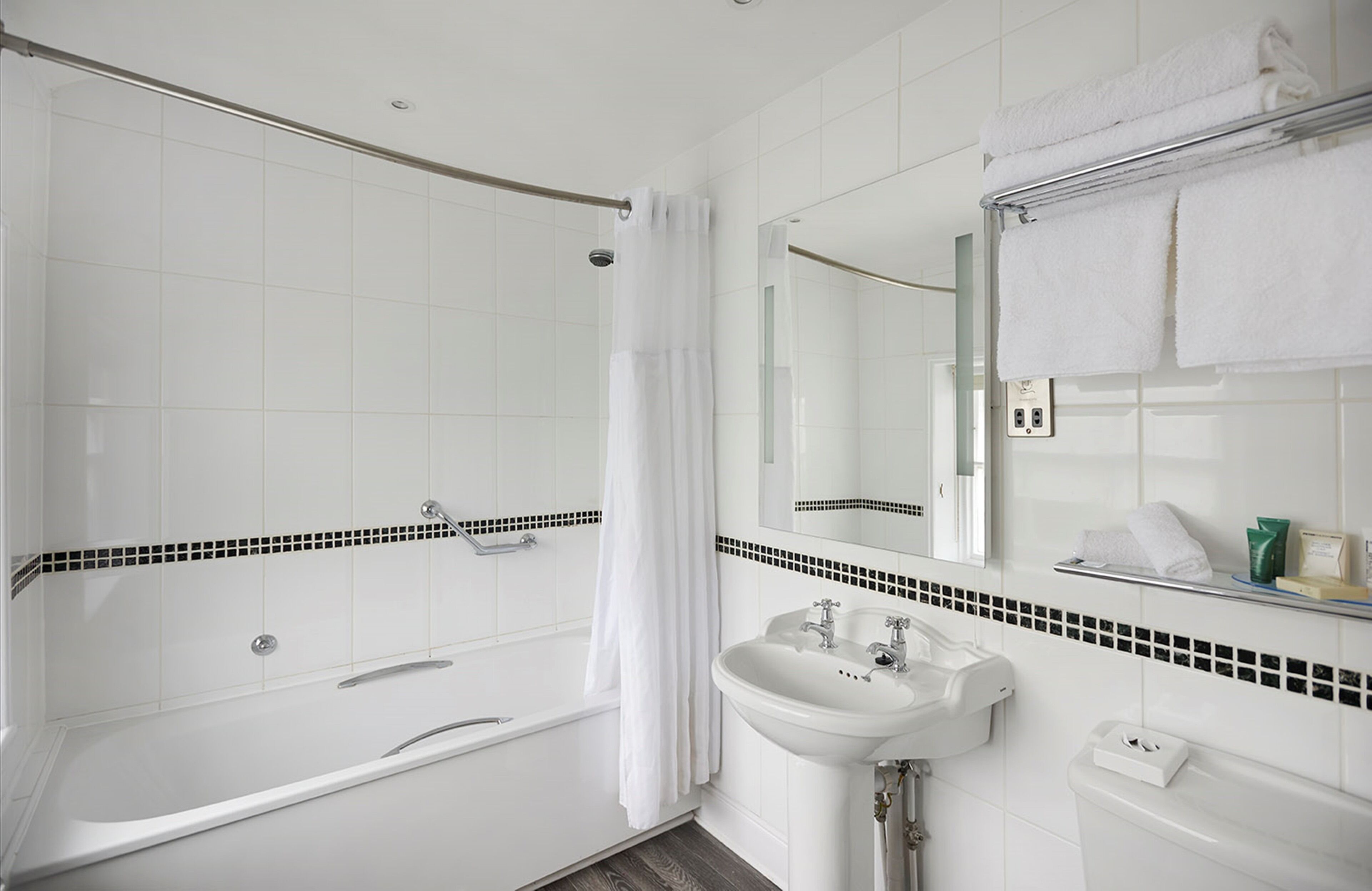 Un baño moderno con ducha a ras de suelo, bañera y lavabo.