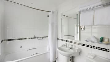 Un baño moderno con ducha a ras de suelo, bañera y lavabo.