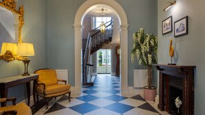 A grand hallway with a checkered floor, a staircase, a chandelier, and a fireplace. - Hilton Puckrup Hall Hotel & Golf Club, Tewkesbury (Tewkesbury)