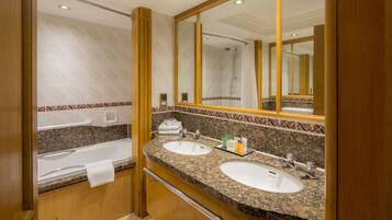 A bathroom with two sinks, a bathtub, and a large mirror.