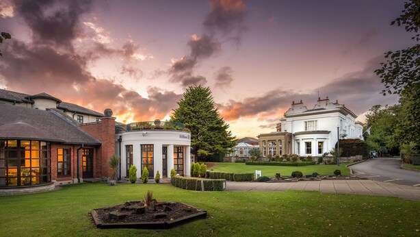 A large, historic building with a well-maintained lawn and a fountain in the foreground. - Hilton Puckrup Hall Hotel & Golf Club, Tewkesbury (Tewkesbury)