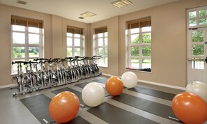 A gym with stationary bikes, exercise balls, and large windows. - Hilton Puckrup Hall Hotel & Golf Club, Tewkesbury (Tewkesbury)