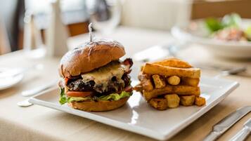 Un plato con una hamburguesa y papas fritas sobre una mesa.
