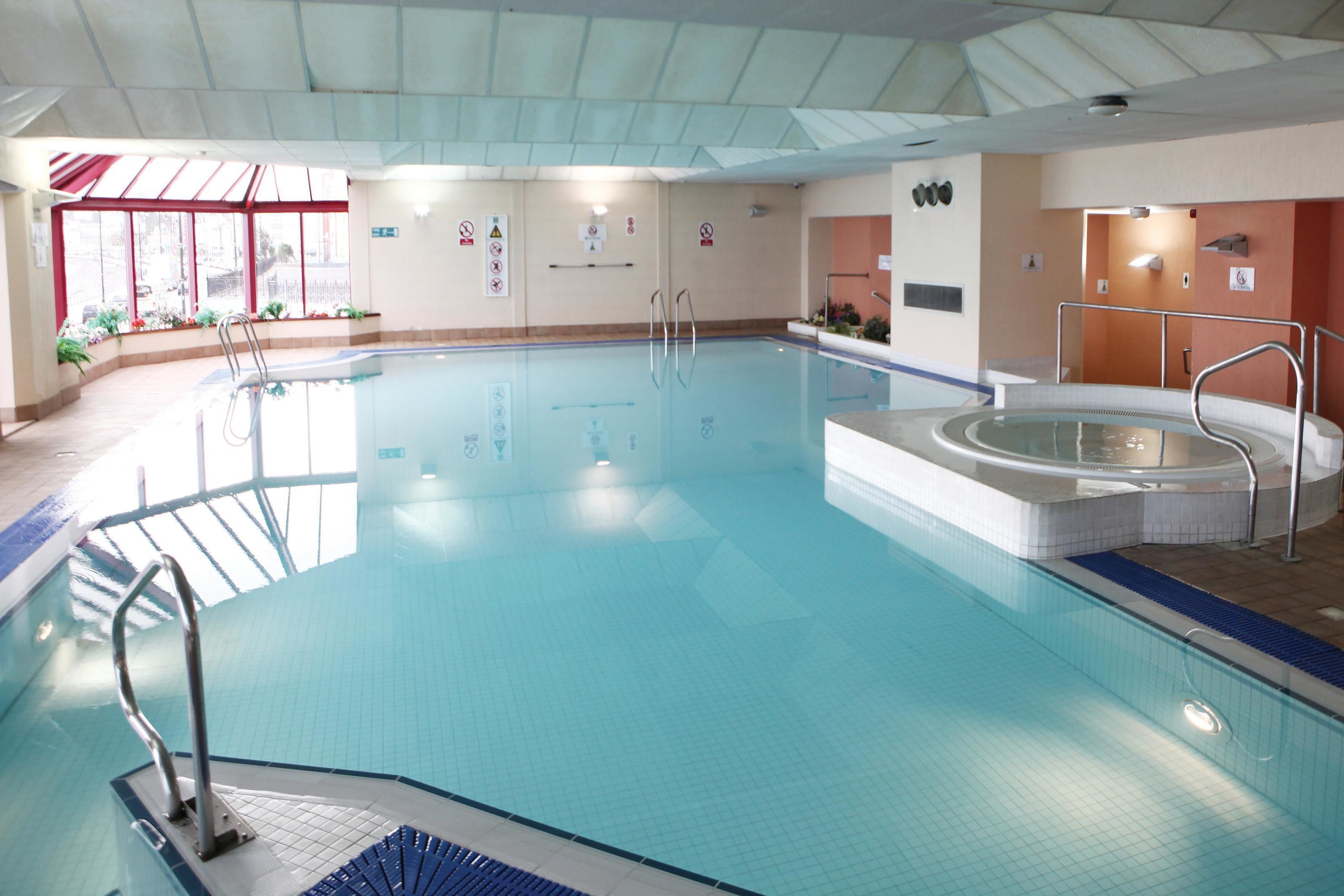 Una piscina techada, sillones reclinables de piscina