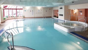 Una piscina cubierta, tumbonas