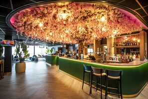 A bar area with a green counter, bar stools, and a ceiling adorned with pink flowers. - Best Western Palace Hotel & Casino (Douglas)