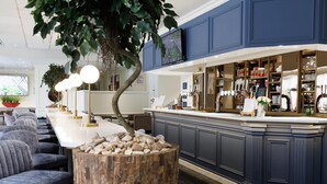 Una cocina moderna con una isla central, asientos tipo bar y un ventanal grande.