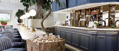 A modern kitchen with a central island, bar seating, and a large window.