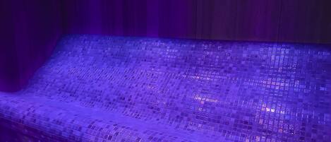 A seating area with a tiled floor and a wooden wall.