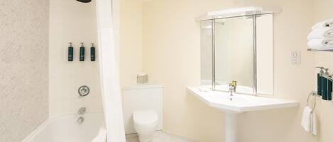 A bathroom with a bathtub, toilet, sink, and a shower with a glass enclosure.