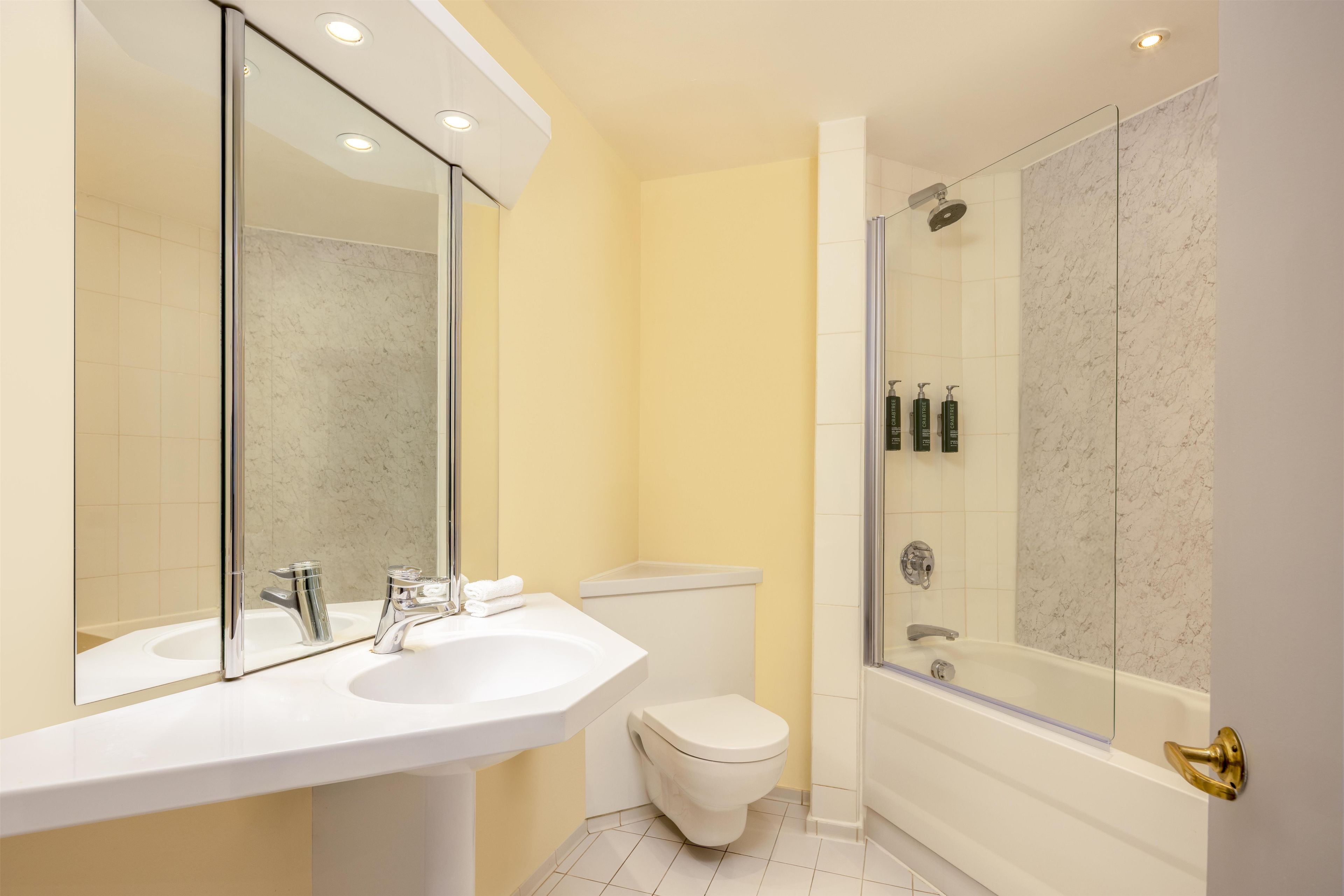 A bathroom with a white sink, a toilet, and a glass-enclosed shower.