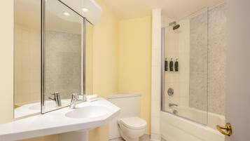 A bathroom with a white sink, a toilet, and a glass-enclosed shower.