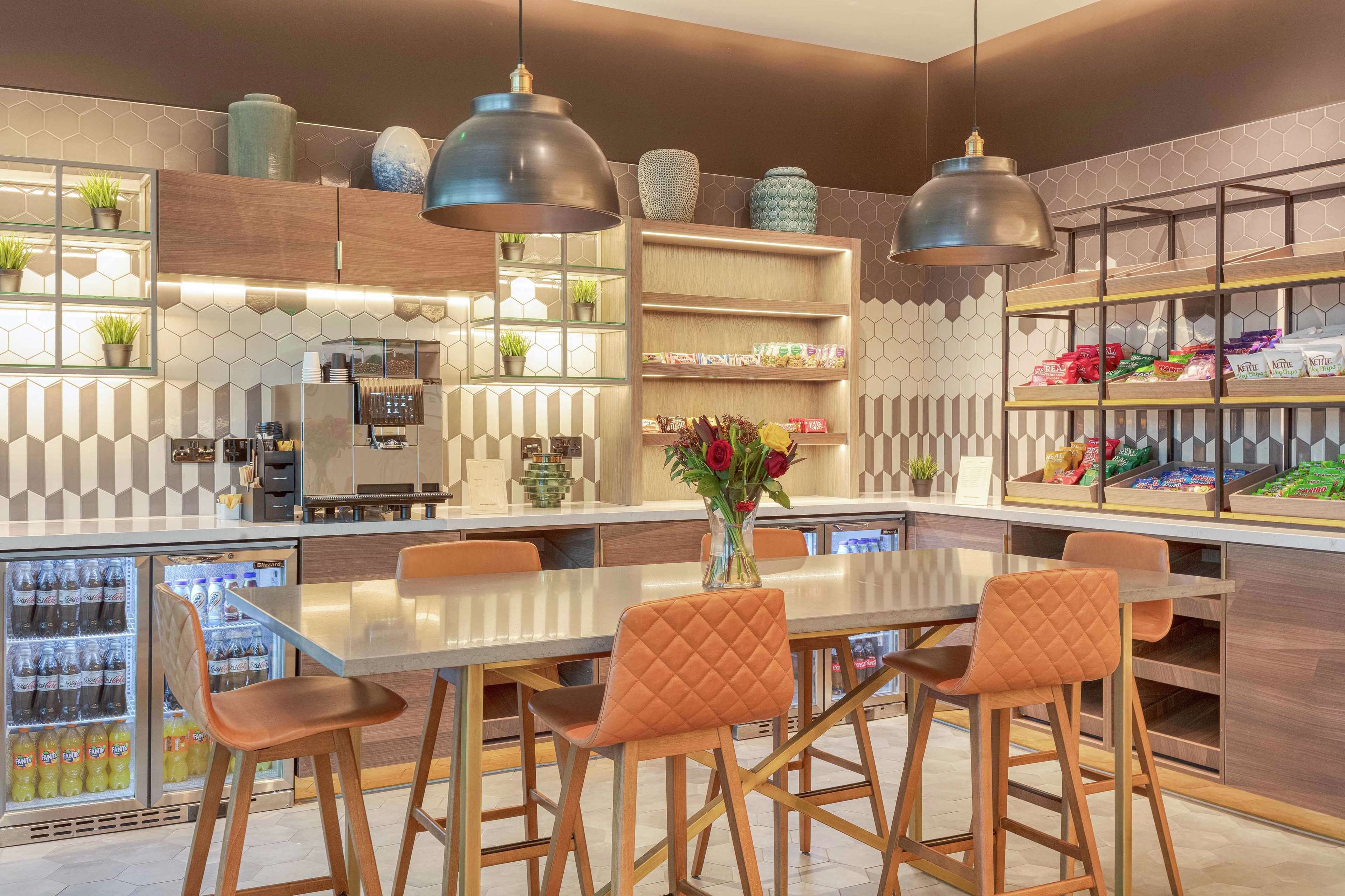 A modern kitchen with a central island, pendant lighting, and a variety of storage options including shelves and cabinets.